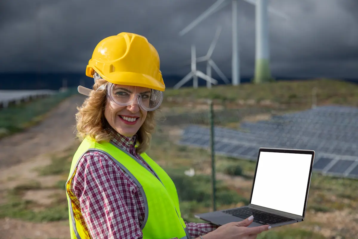 Female renewable energy engineer poses with laptop, demonstrating importance of STEM in the classroom.