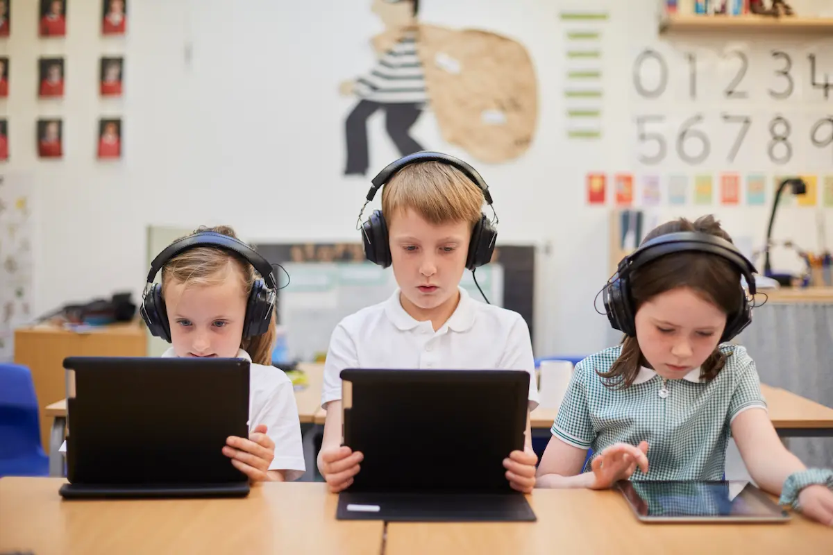 Children listen to podcasts for teachers to play for their classroom. 