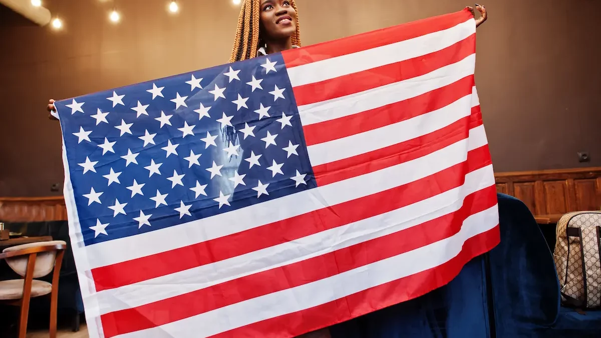 An African American woman proudly holds the American flag for Juneteenth.
