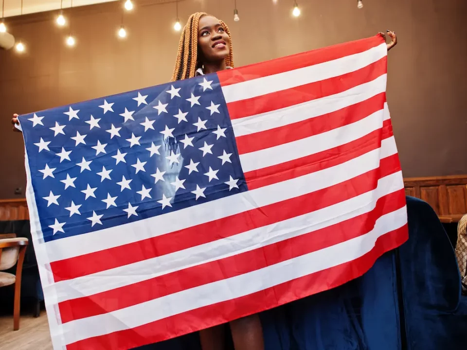 An African American woman proudly holds the American flag for Juneteenth.