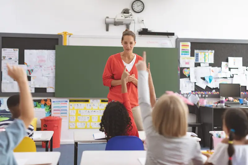 A happy teacher leads her class, having taken steps to avoid teacher burnout. 