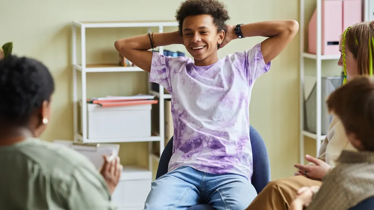 A teenager smiles in a group counseling session for good mental health.