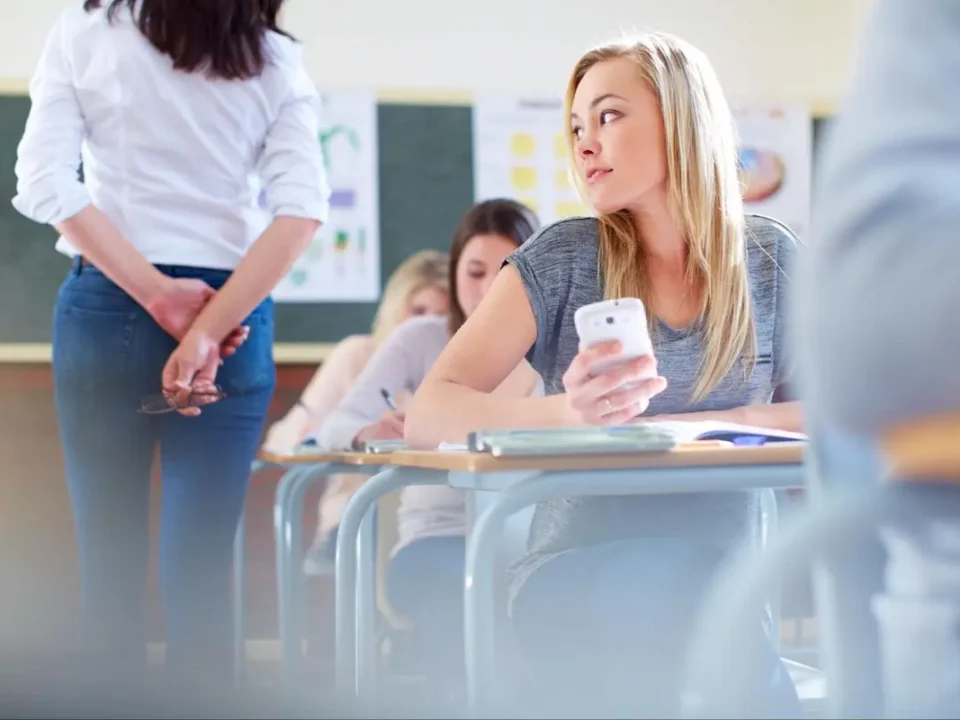 Female student sneaks a peek at her phone during class time.