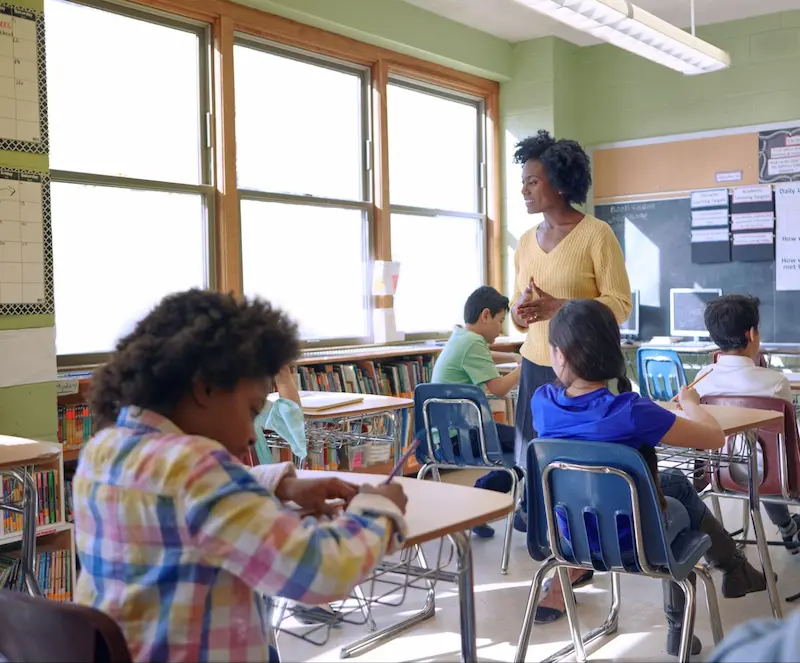 Female student sneaks a peek at her phone during class time.  
