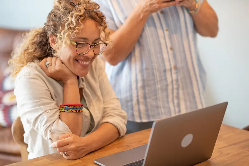 Teacher smiles after revising and resubmitting funding request.