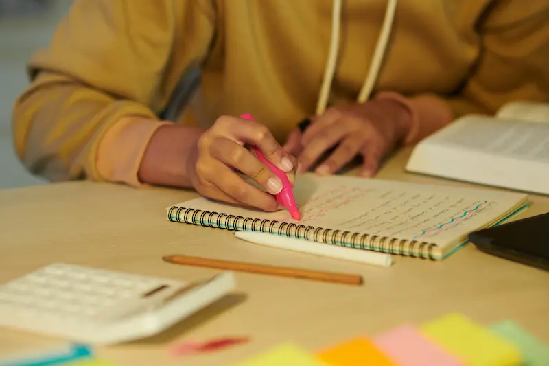 Student highlighting text in a planner.